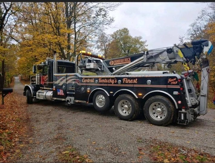 Heavy-duty tow truck parked on a wooded Kentucky driveway